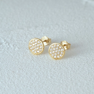 Close-up of gold stud earrings with cubic zirconia pave setting and minimalist design