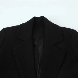 Close-up of black woolen coat collar featuring notched lapels and silk lining details
