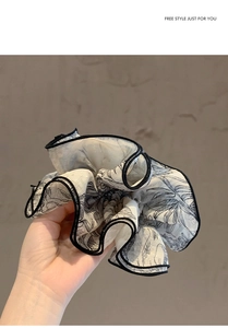 Detalle de coletero grande de gasa con estampado floral negro y blanco y borde negro fino