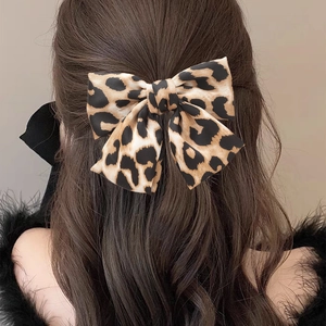 Leopard print bow hair clip on model back view with elegant satin fabric finish