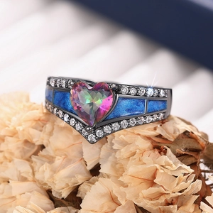 Vista macro de anillo de corazón con topacio místico, metal negro y esmalte azul