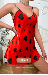 Détail de la nuisette en satin rouge avec imprimé cœurs noirs et fines bretelles