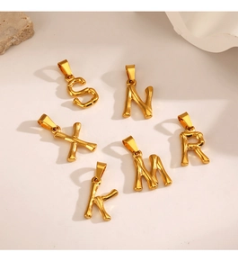 Macro view of gold bamboo style alphabet charms including S N X M R K letters