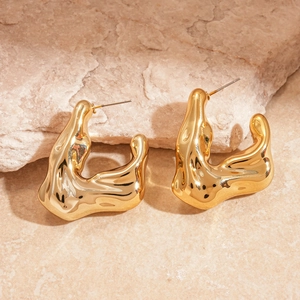 Detailed macro view of liquid gold style earrings with irregular fluid metal texture