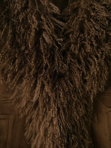 Close-up of deep brown faux fur collar and textured suede fabric of the winter jacket