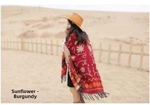 Detail of wine red bohemian shawl with sunflower patterns and long fringe in the desert