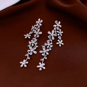 Elegant silver flower tassel earrings with zircons on dark red velvet background