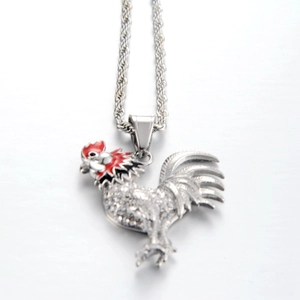 Detailed shot of rooster pendant with red enamel comb and sparkling zircon stones