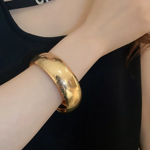 Detailed view of wide gold cuff bracelet featuring vintage crocodile scale texture on wrist