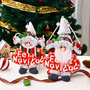 Detail of plush Santa and Snowman ornaments with Feliz Navidad sign on a festive Christmas tree