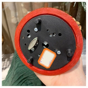 Detail view showing the bottom mechanical wind-up clockwork of the snow globe music box