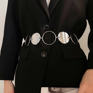 Detail of silver oval geometric link waist chain on a black tailored blazer jacket