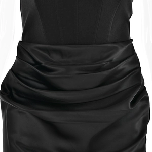 Détail du plissé à la taille et de la texture du satin noir de cette robe dos nu