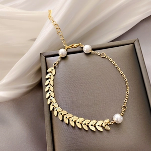 Detailed view of leaf shaped gold bracelet with white pearls and adjustable chain