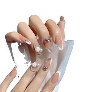 Faux ongles faits main avec roses blanches, perles et cristaux sur un design French