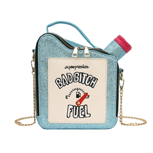Detailed view of light blue sequined oil can bag with embroidered letters and chain strap