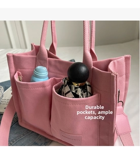 Dettaglio della borsa tote in tela rosa con tasche esterne e ampio spazio interno
