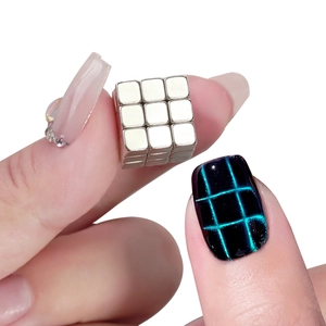 Macro shot of 18 silver cube magnets for creating checkered cat eye nail art patterns
