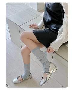 Close-up of thin breathable mesh leg warmers with vertical stripes and Mary Jane shoes