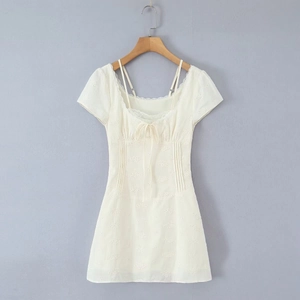 Short off-white dress featuring floral embroidery, puff sleeves, and lace trim detailing