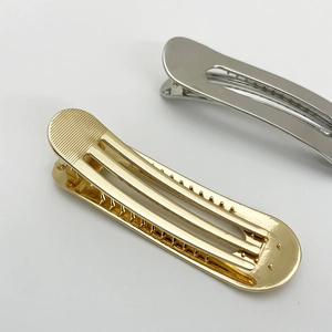 Detail view of gold and silver alloy hair clips with metal teeth and spring mechanism