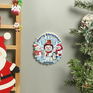 Close-up of a 3D resin Christmas magnet featuring a snowman and penguin design