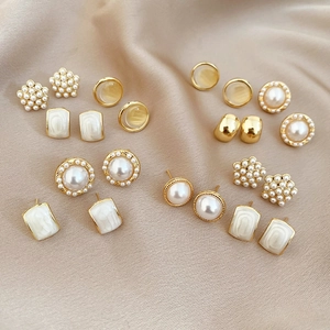 Close-up of pearl and gold earring set on silk background showing vintage details