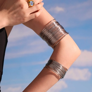Multi-layer hollow arm cuff bracelet in polished silver stainless steel with sky background