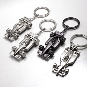 Formula 1 race car metal keychains in silver and black finishes shown in diagonal layout