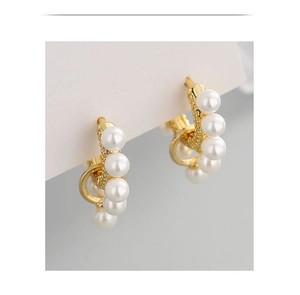 Macro shot of gold hoop earrings set with neat rows of polished white pearls
