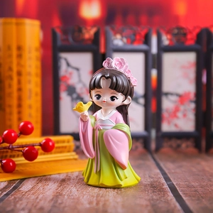 Detailed close-up of a Chinese style resin figurine in Hanfu holding a small yellow bird
