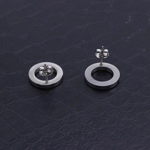Minimalist silver stainless steel hoop earrings on a black crocodile leather background
