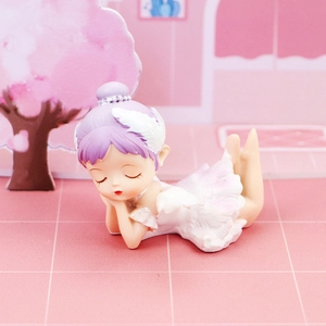 Close-up of a sleeping resin ballerina figurine with white feather tutu and purple hair