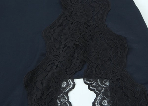 Makroaufnahme von feinen schwarzen Spitzendetails und Stofftextur auf einem Satin-Minikleid