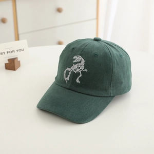 Close-up of a dark green kids baseball cap with white dinosaur skeleton embroidery