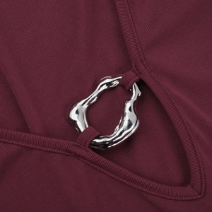 Close-up of wine red ribbed fabric with a silver irregular metal ring detail