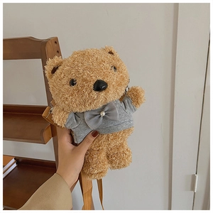 Detail of plush brown teddy bear bag with grey hoodie, pearl decor, and brown shoulder strap