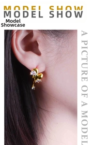 Close-up of heart-shaped 18K gold-plated earring with zircons worn by a model
