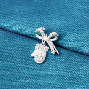 Christmas bow and snowflake glove charm with rhinestones on teal silk background