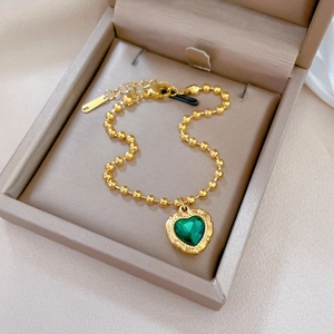 Titanium steel gold beaded bracelet featuring a vintage green heart pendant in a jewelry box