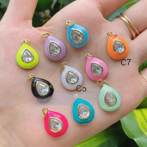 Detailed view of colorful enamel teardrop pendants with inlaid pear-cut cubic zirconia