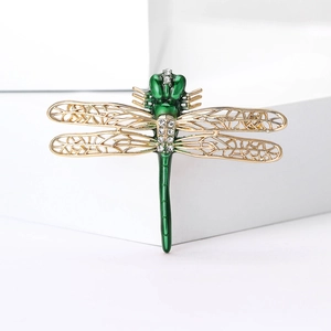 Detail of green enamel dragonfly brooch with gold hollow wings and clear rhinestones