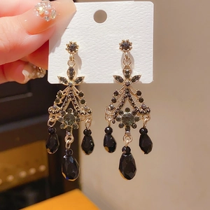 Close-up of vintage black crystal tassel earrings with gold-tone metal and 925 silver pins