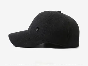 Detail of dark grey wool blend baseball cap with side metal R logo and warm texture