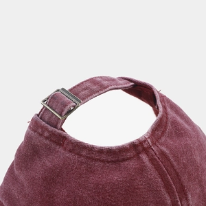 Dettaglio del cappellino bordeaux lavato con fibbia di regolazione in metallo bronzato