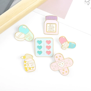 Cute medical enamel pins featuring pill bottles and bandaids with pastel colors