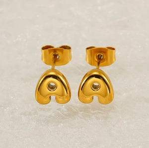 Close-up of 18K gold plated 3D bubble letter 'a' stud earrings with mirror finish