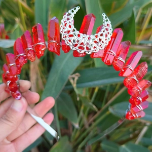 Detail of red raw crystal crown with silver wire wrap and hollow moon ornament