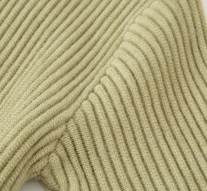 Macro shot of light green rib knit fabric showing high-quality stitching and texture
