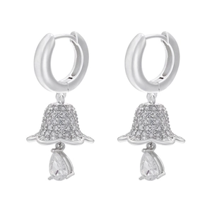 Macro shot of silver lily flower earrings with micro-set zircon and pear-shaped pendants